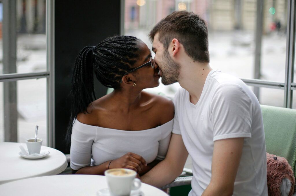 Man and woman ending their date with a kiss